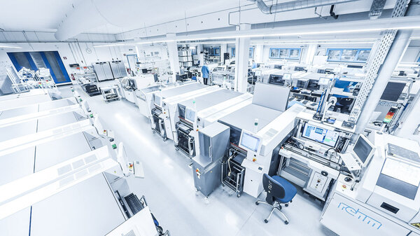 Blick in den Produktionsbereich, im Vordergrund sind SMT-Maschinen zu sehen